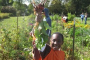 A youth holding some vegetables.